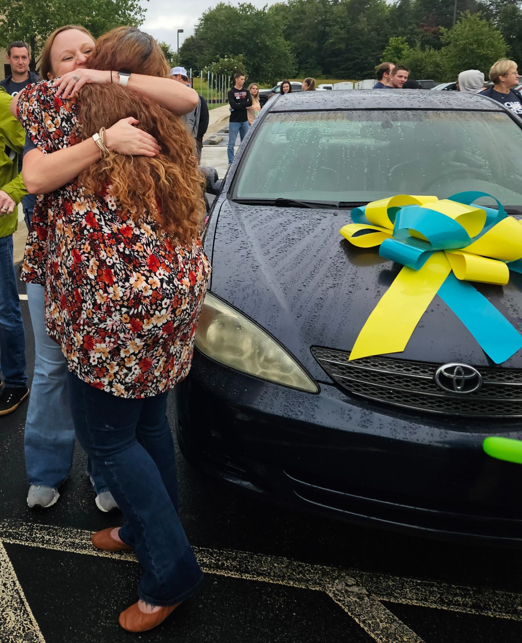 LC embraces a supporter in front of her sweet new ride