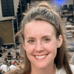 a woman with brown hair wears her hair half up, half down and smiles
